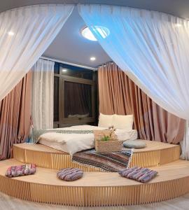 una camera da letto con un letto con cuscini sopra di Kang's Home Vũ Miên a Hanoi