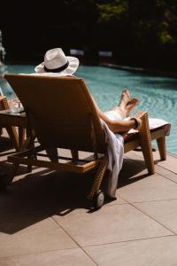 a man sitting in a chair next to a pool at DAS RONACHER Thermal Spa Hotel in Bad Kleinkirchheim