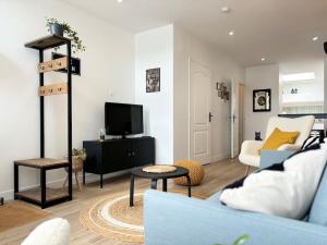 a living room with a couch and a tv at Maison rénovée 4 personnes - Prox Lille in Marquette-lès-Lille