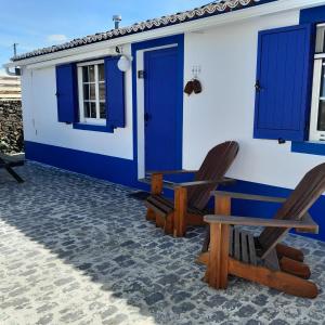 dom z dwoma krzesłami i niebieskimi drzwiami w obiekcie Vacas Felizes Villas - Casa do Badalo w mieście Rabo de Peixe