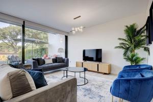 a living room with a couch and a tv at Modern Townhouse on San Roque Golf Club in San Roque