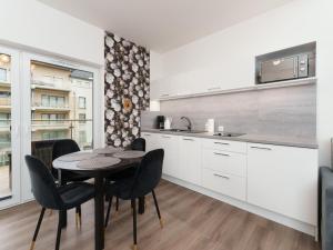 a kitchen with a table and chairs in a room at Apartament Sailor by HolidaySun in Sianozety