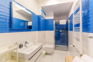 a blue and white bathroom with a sink and a shower at Apartament Sailor by HolidaySun in Sianozety