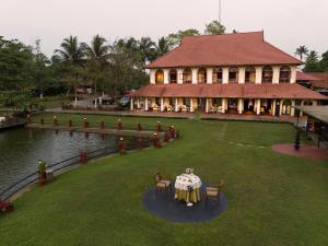 庫瑪拉孔的住宿－Taj Kumarakom Resort and Spa Kerala，房屋前方设有桌椅