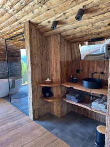 bagno in legno con lavandino e vasca di Chasa Veglia a Sent