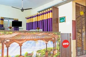 una habitación con un escenario con una pintura en la pared en OYO NSK Mahanadu Extension, en Gunadala
