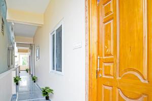 otwarte drewniane drzwi w korytarzu z roślinami w obiekcie OYO NSK Mahanadu Extension w mieście Gunadala
