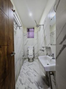 ein Bad mit einem Waschbecken und einem WC in der Unterkunft Hotel ARRAJ, Raipur in Raipur