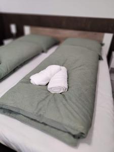 a white towel laying on top of a bed at NassaFlat Apartman in Pécs
