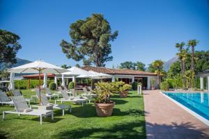 阿斯科納的住宿－Villa Favorita - Parkhotel Delta，一组椅子和遮阳伞,位于游泳池旁