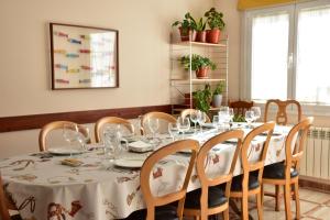 Obanos的住宿－CASA RAICHU，用餐室配有桌椅和酒杯