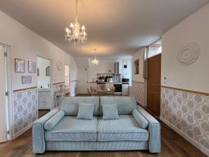 a living room with a blue couch and a kitchen at Le Renaissance - Home Homy in Montluçon