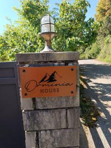 a sign for a mountain house on a stone wall at orminia house upper level 