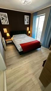 1 dormitorio con 1 cama y suelo de madera en Piata Ovidiu Square, en Constanţa