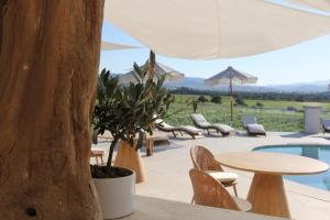 a patio with a table and chairs and a pool at Villa Agostina in Murta Maria