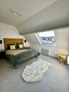 een slaapkamer met een bed en een wit tapijt bij Anémone in Audresselles