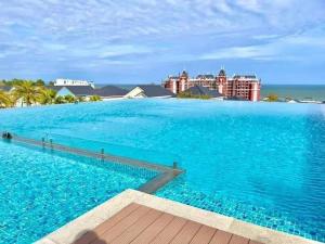 a swimming pool with blue water and buildings in the background at Villa NovaWorld Phan Thiết 4PN view vườn cho 6-8 pax in Bình Tú