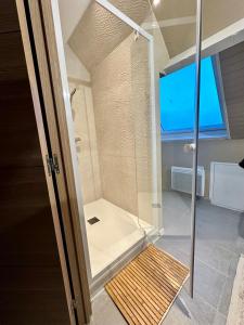 een douche met een glazen deur in de badkamer bij Anémone in Audresselles