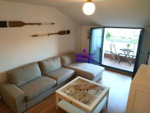 ein Wohnzimmer mit einem Sofa und einem Tisch in der Unterkunft O Faro, a 150 mtrs de playa Corna in San Pedro
