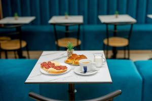 einen Tisch mit einem Teller Essen und einer Tasse Kaffee in der Unterkunft Lucky Hotel in Weliko Tarnowo