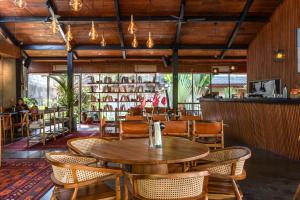 un restaurante con mesa de madera y sillas en MASMARA Resort Canggu, en Canggu