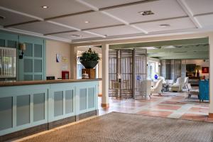 eine Lobby mit Bar und Wohnzimmer in der Unterkunft AZZ Castellar Hacienda El Alcornocal in Castellar de la Frontera