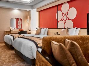 Daiwa Roynet Hotel KANAZAWA-MIYABI في كانازاوا: غرفة فندقية بسريرين وجدار احمر