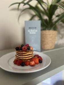 einen Teller mit Pfannkuchen und Beeren auf dem Tisch in der Unterkunft Fairlawn House in Amesbury