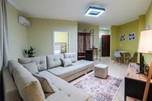 een woonkamer met een witte bank en een tafel bij ApartHotel EDA in Durrës