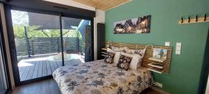 Schlafzimmer mit einem Bett und einer Glasschiebetür in der Unterkunft Le Jardin des Ecureuils in Dijon