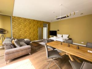 Exklusives Leipzig City Apartment Sunrise في لايبزيغ: غرفة معيشة مع أريكة وطاولة