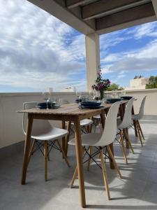 a wooden table with chairs and wine glasses on a patio at Grande corner villa in Isla Plana by the sea in Isla Plana