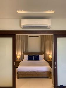 a bedroom with a bed with blue pillows at Lake View Luxury Suite, Hawana Resort in Salalah