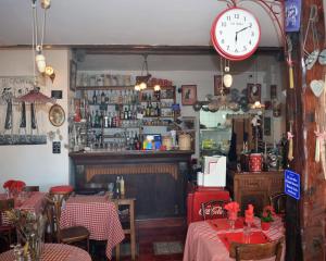 a restaurant with two tables and a clock on the wall at Hotel Le Patio in Théoule-sur-Mer