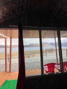 a room with a window with a view of the ocean at Padma Cottage Pangong in Spangmik