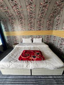 a bed with a red blanket on it in a bedroom at Padma Cottage Pangong in Spangmik