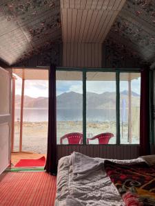 a bedroom with a bed and a view of the ocean at Padma Cottage Pangong in Spangmik