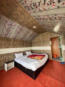 a bedroom with a large bed with a wooden ceiling at Padma Cottage Pangong in Spangmik