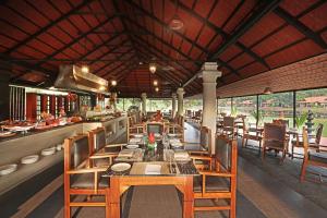 restauracja z dużym stołem i krzesłami w obiekcie Taj Kumarakom Resort and Spa Kerala w mieście Kumarakom