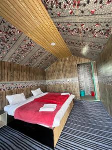 a bedroom with a large bed with a red blanket at Padma Cottage Pangong in Spangmik
