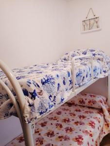 Cama en habitación con sábanas azules y blancas en Affittimoderni Valledoria - La Casa di Lavinia, en Valledoria