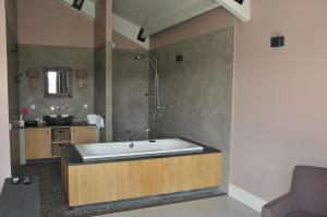 a large bathroom with a tub and a sink at Erve 't Hacht in Ane