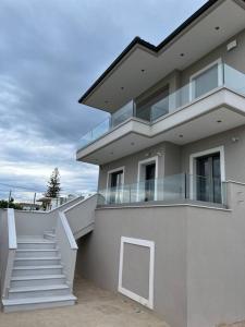 a white building with a staircase in front of it at Villa Maria Eirini in Lechaio +26 photos