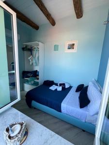a blue bedroom with a bed and a mirror at Suite annarè, casa al mare, casa vacanza al mare in Sorrento