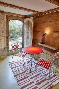 a red table and chairs in a room with a window at Baudenkmal Mühle Schalchen 