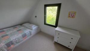 a bedroom with a bed and a window at Mandulás nyaraló in Zánka