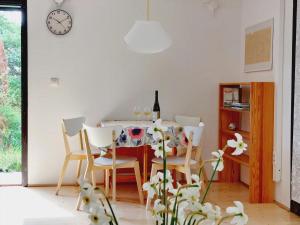a dining room with a table with chairs and a clock at Mandulás nyaraló in Zánka