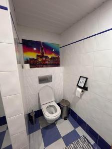 a bathroom with a toilet and a painting on the wall at Alcmaria studio with amazing views at ZevariClub! in Folhadosa +39 photos