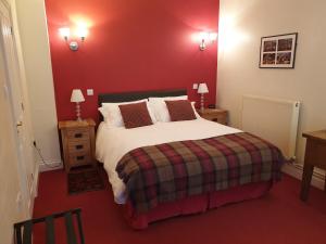 um quarto com uma cama grande e uma parede vermelha em The Old Cannon Brewery em Bury Saint Edmunds