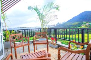 a balcony with benches and a view of a mountain at Aquaa Leaf Residences in Nuwara Eliya
